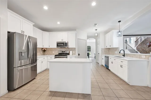 a kitchen with white cabinets and stainless steel appliances