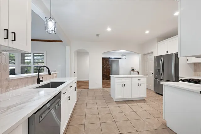 a large kitchen with a stove a sink and a refrigerator