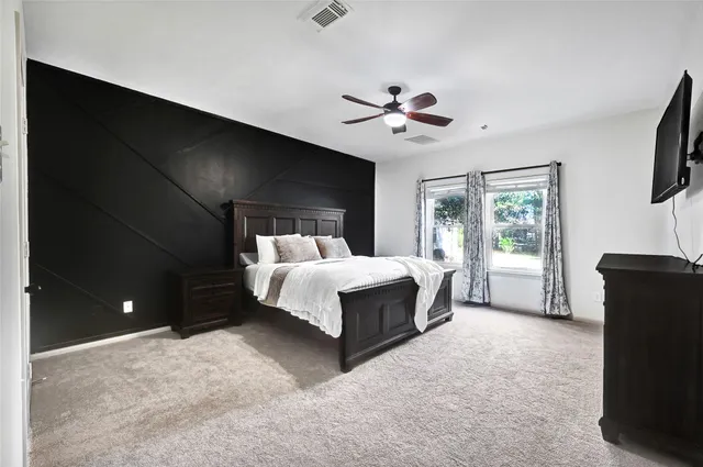 a spacious bedroom with a bed and a chandelier