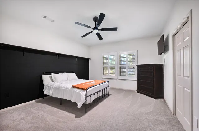 a bedroom with a bed and a ceiling fan