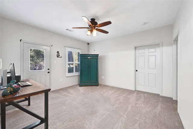 a view of a livingroom with workspace and a window