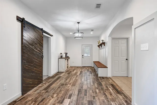 a view of a hallway with wooden floor and staircase