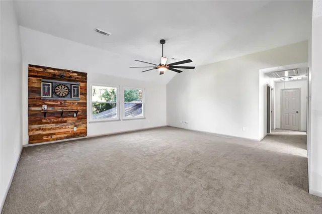 a view of room with an entryway and a ceiling fan
