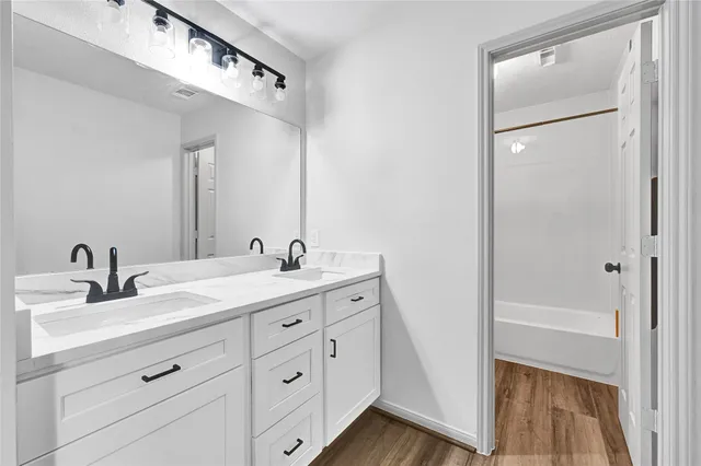 a bathroom with a double vanity sink and mirror
