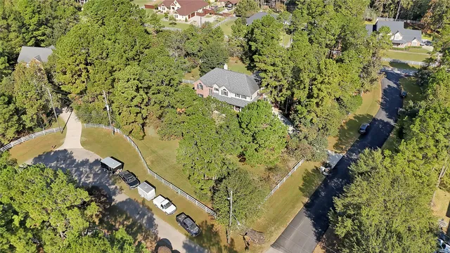 an aerial view of residential houses with outdoor space and trees