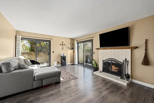 a living room with furniture a fireplace and a flat screen tv