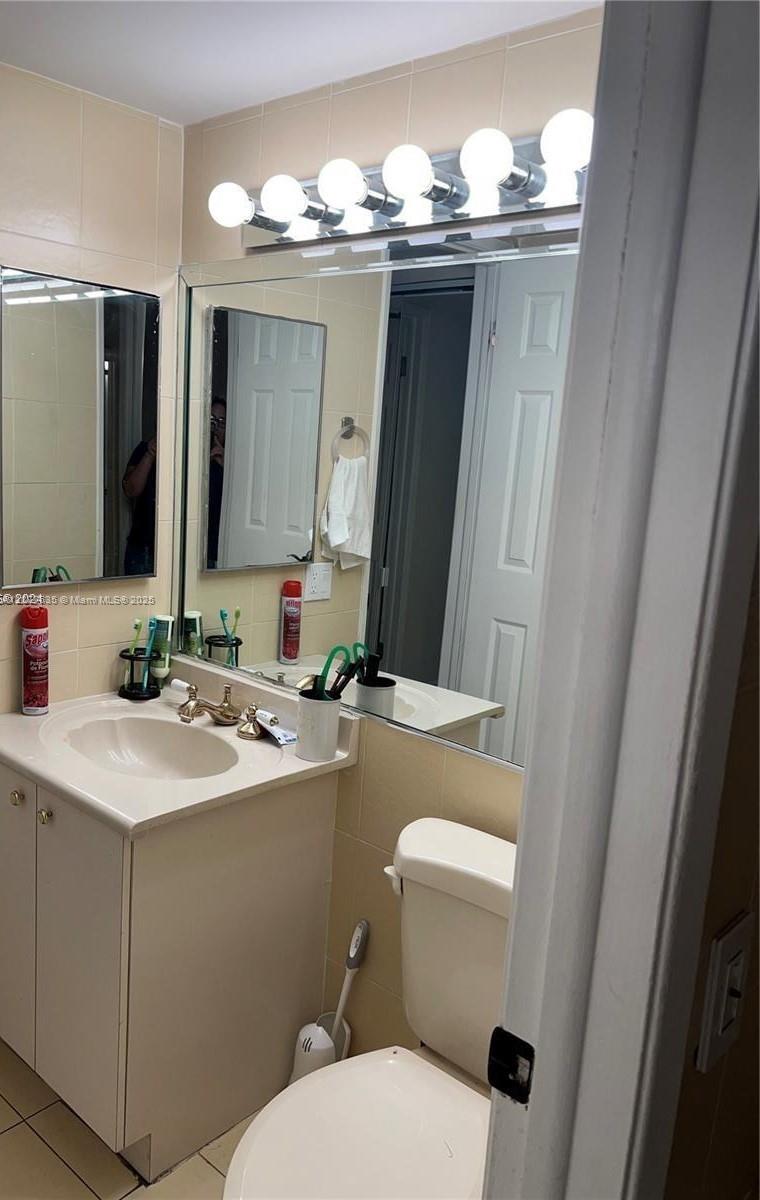 8875 Fontainebleau Boulevard, Unit 203 Miami, FL 33172 - Photo 12 of 22 a bathroom with a sink vanity mirror and toilet