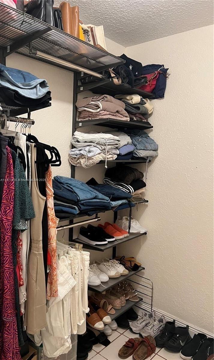 8875 Fontainebleau Boulevard, Unit 203 Miami, FL 33172 - Photo 17 of 22 a view of walk in closet with clothes and shoes