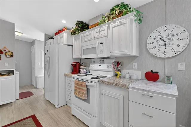 a kitchen with white cabinets and white appliances