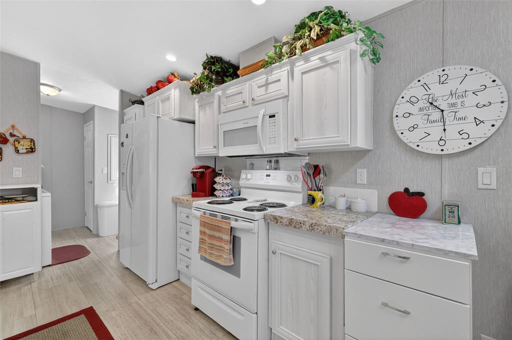 11523 Marvell Way Leesburg, FL 34788 - Photo 11 of 40 a kitchen with white cabinets and white appliances