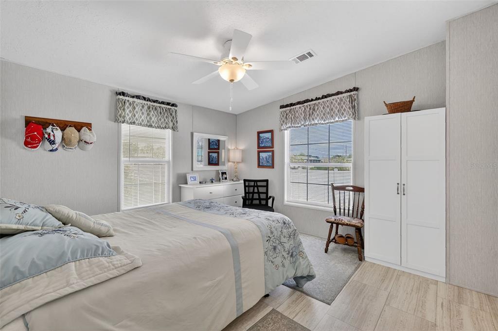 11523 Marvell Way Leesburg, FL 34788 - Photo 15 of 40 a spacious bedroom with a bed and a chandelier