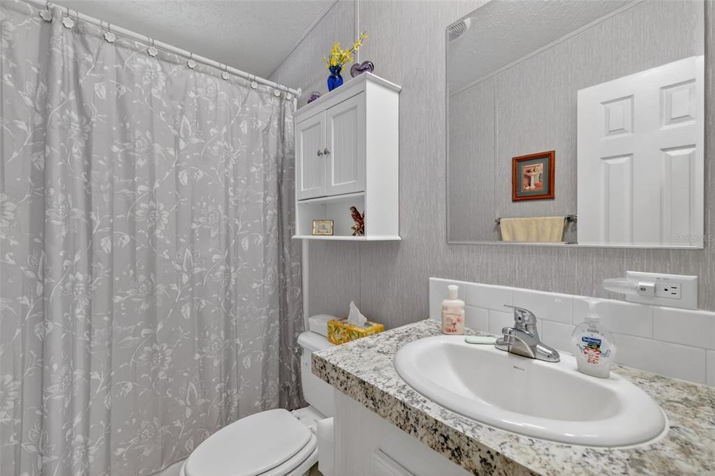 11523 Marvell Way Leesburg, FL 34788 - Photo 21 of 40 a bathroom with a sink a toilet and a mirror