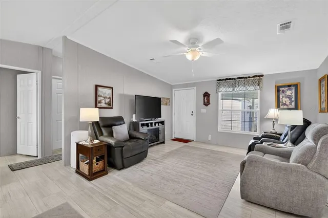 a living room with furniture a ceiling fan and a window