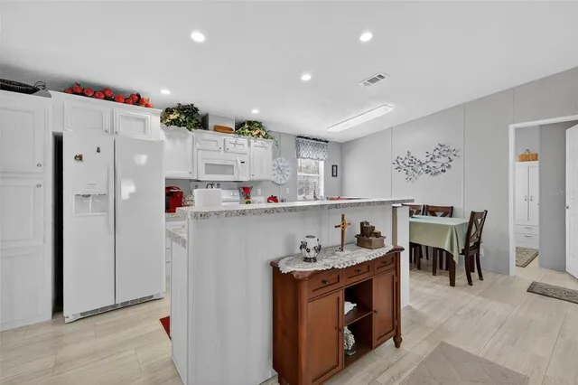 a kitchen with stainless steel appliances granite countertop a refrigerator and a table