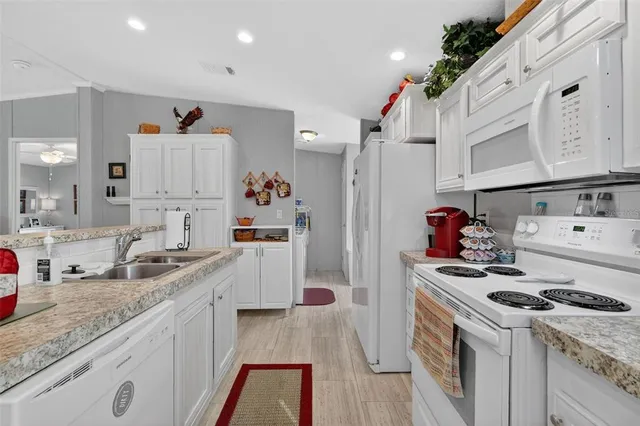 a kitchen with granite countertop a sink stove and refrigerator
