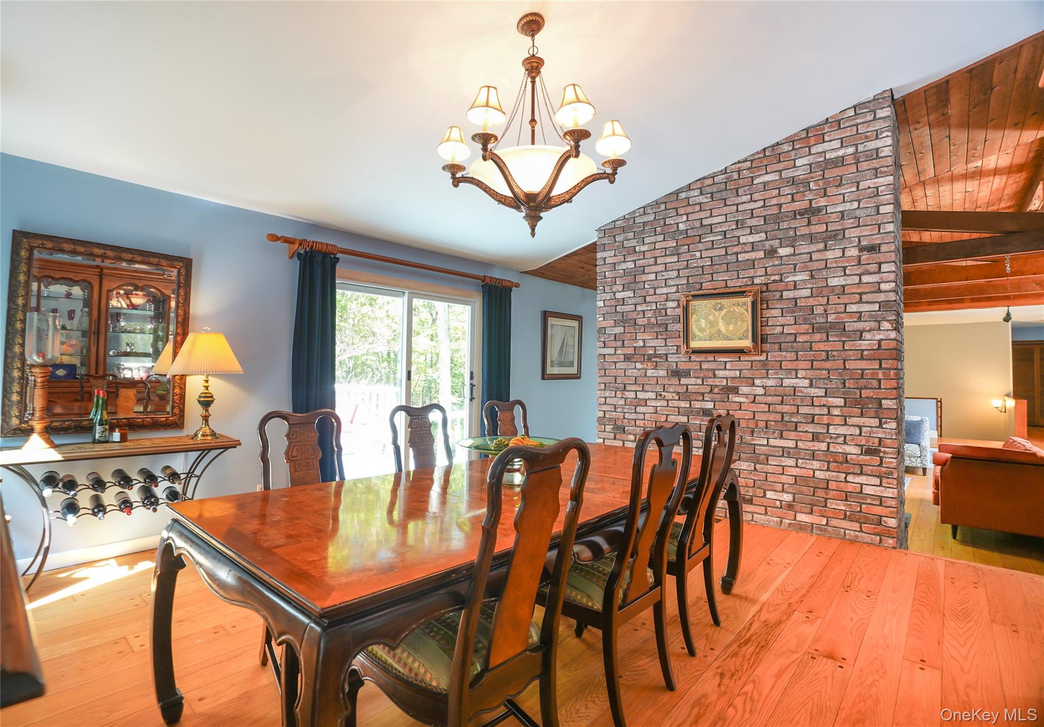 22 Peters Lane Pound Ridge, NY 10576 - Photo 15 of 43 Dining area featuring light wood-finish flooring, a contemporary chandelier, and a sliding glass door