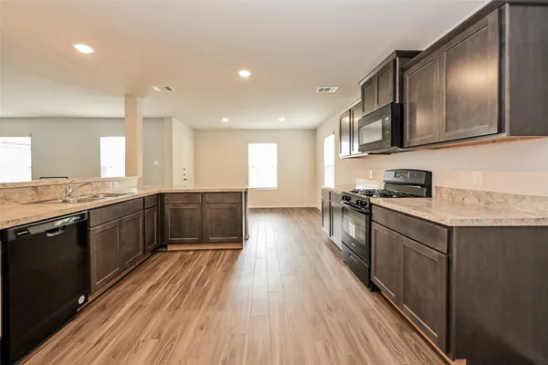 a kitchen with a sink and wooden floor