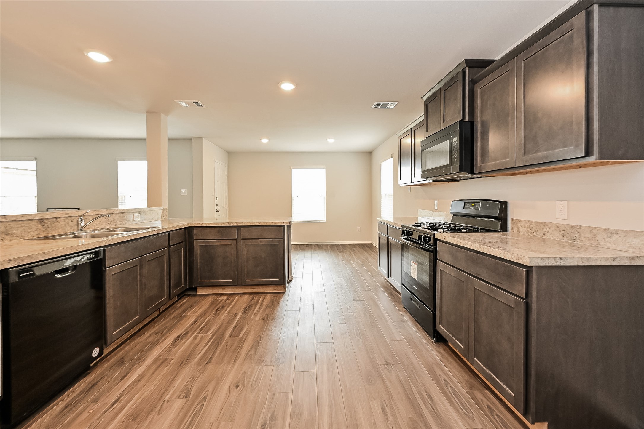 1128 Copal Trail Conroe, TX 77301 - Photo 4 of 22 a kitchen with a sink and wooden floor