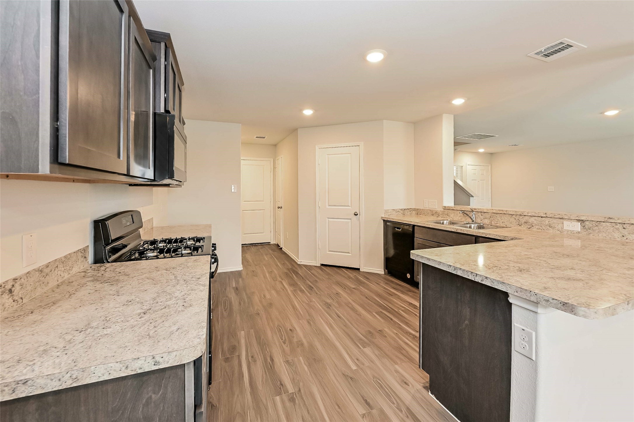 1128 Copal Trail Conroe, TX 77301 - Photo 6 of 22 a kitchen with a sink a stove and a refrigerator