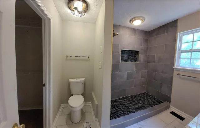a bathroom with a toilet and a shower