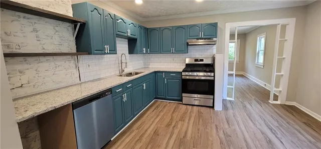 a kitchen with stainless steel appliances granite countertop a refrigerator and a sink