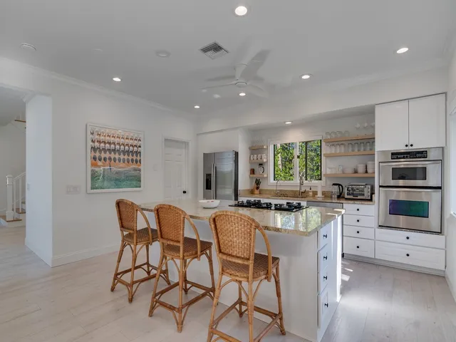 a kitchen with stainless steel appliances a table and chairs in it