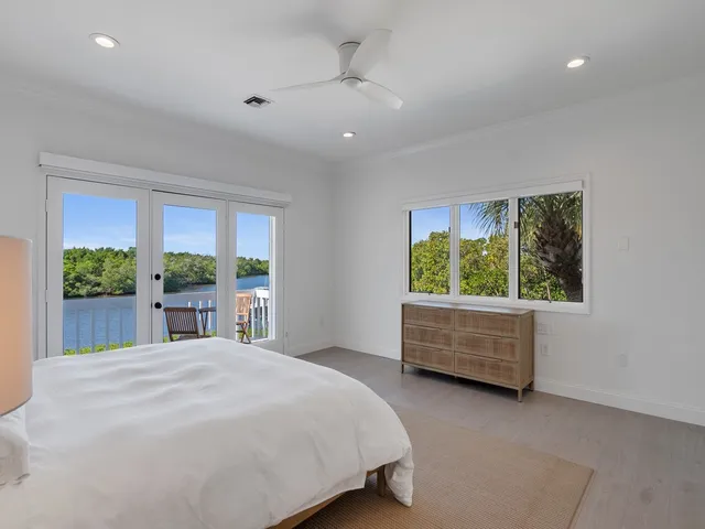 a bedroom with a bed mirror and window