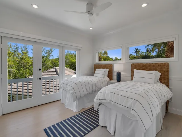 a bedroom with two beds and a window