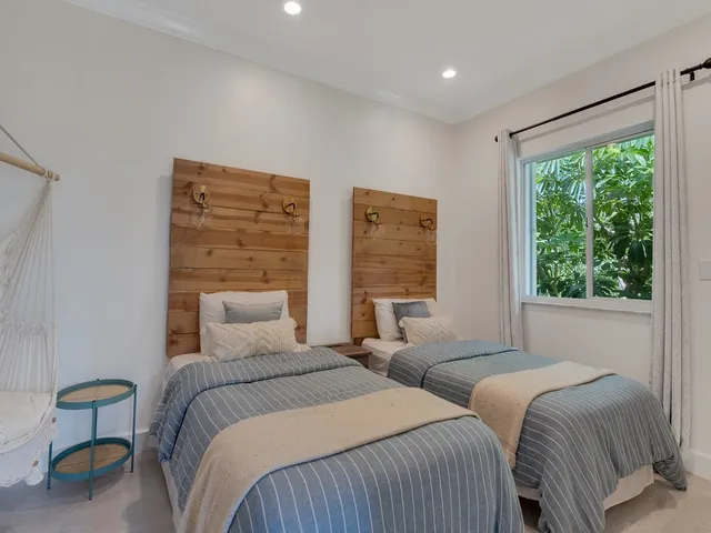 a bedroom with two beds and a large window