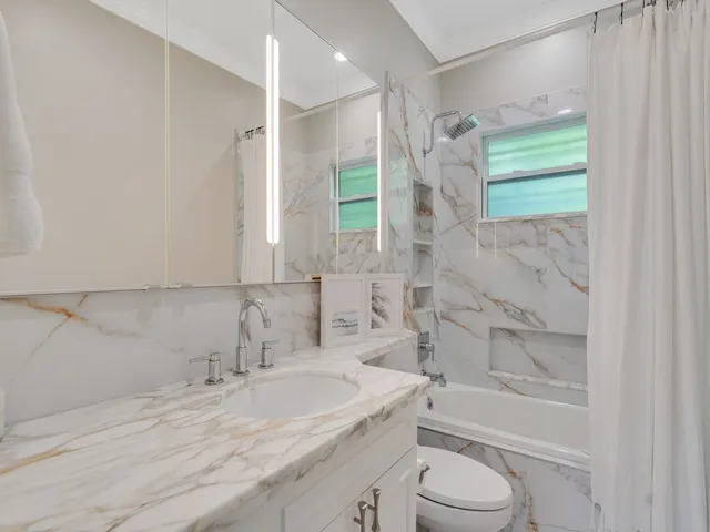 a bathroom with a granite countertop sink toilet a shower and a bathtub