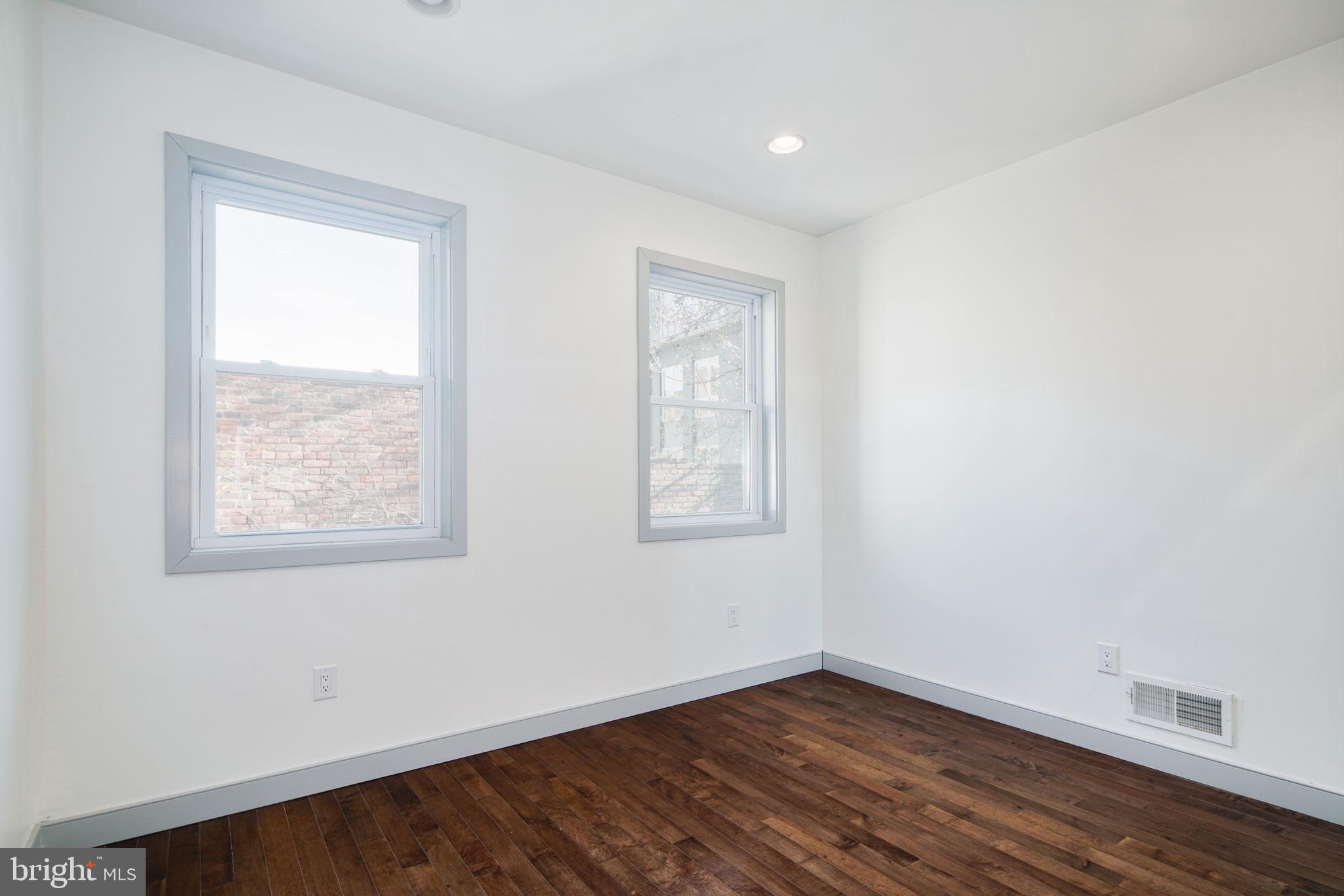 1235 North Taney Street Philadelphia, PA 19121 - Photo 12 of 28 an empty room with wooden floor and windows