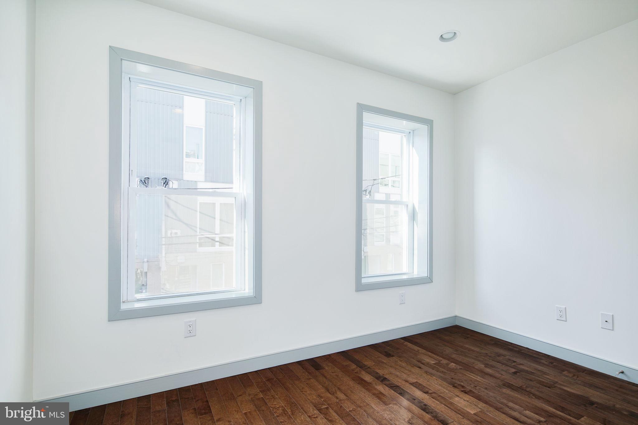 1235 North Taney Street Philadelphia, PA 19121 - Photo 15 of 28 an empty room with wooden floor and windows