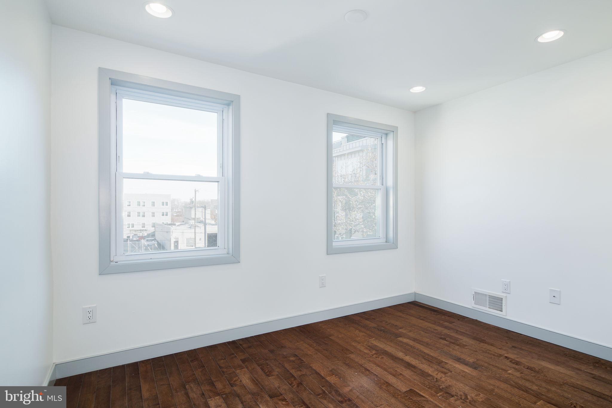 1235 North Taney Street Philadelphia, PA 19121 - Photo 19 of 28 an empty room with wooden floor and windows