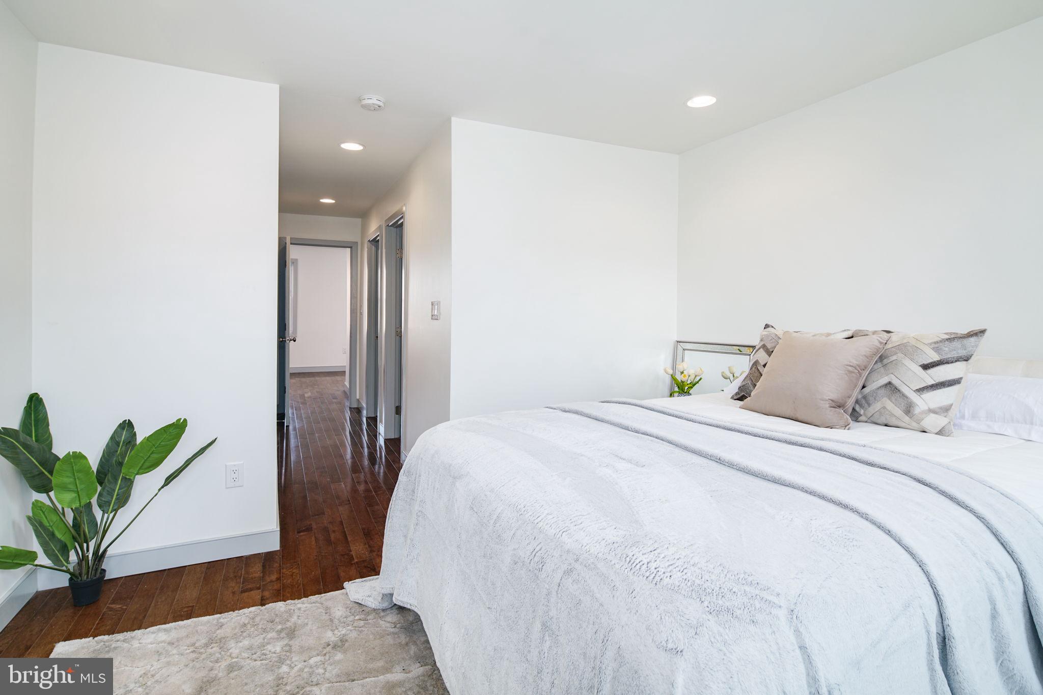 1235 North Taney Street Philadelphia, PA 19121 - Photo 22 of 28 a bedroom with a large bed and a potted plant