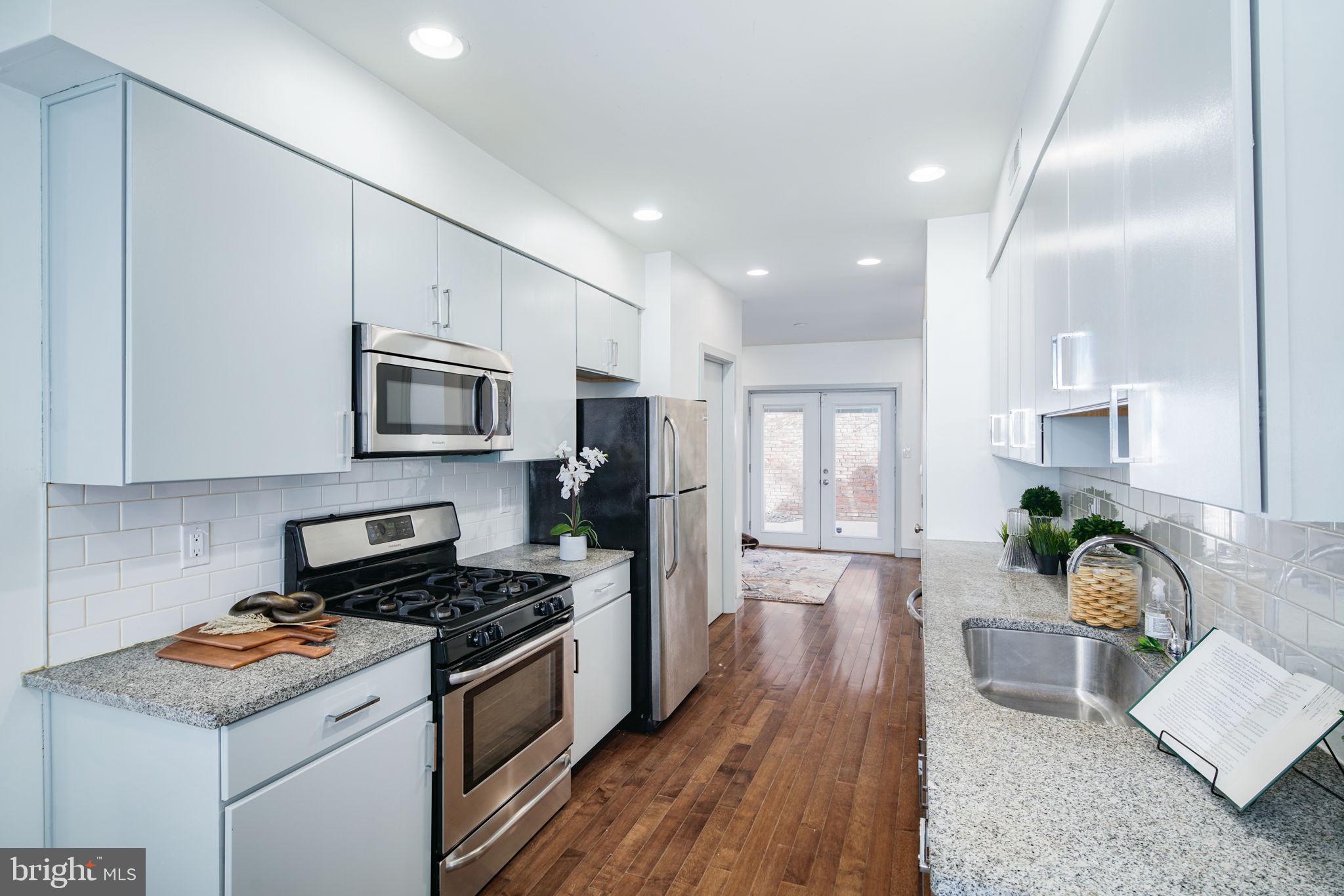 1235 North Taney Street Philadelphia, PA 19121 - Photo 4 of 28 a kitchen with a stove a sink and a refrigerator