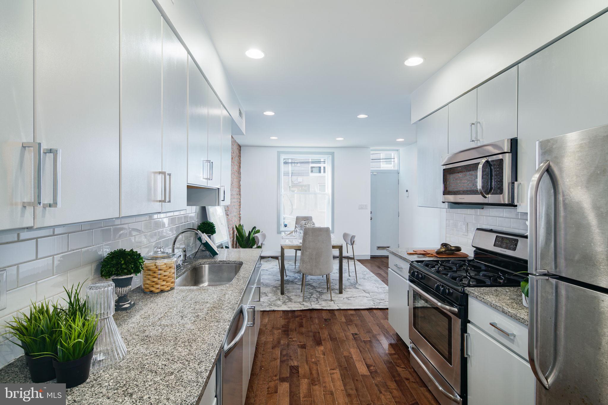1235 North Taney Street Philadelphia, PA 19121 - Photo 6 of 28 a kitchen with stainless steel appliances granite countertop sink stove top oven and cabinets