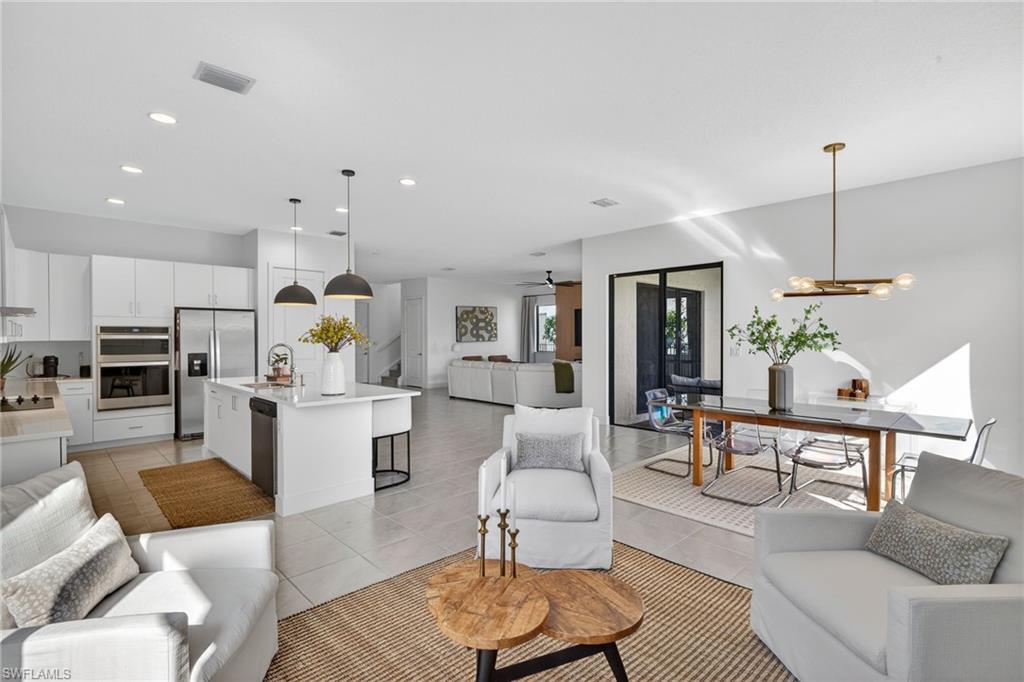 a living room with furniture kitchen view and a chandelier