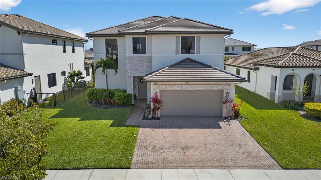 5104 Isidora Lane Ave Maria, FL 34142 - Photo 26 of 28 a front view of a house with a yard and garage