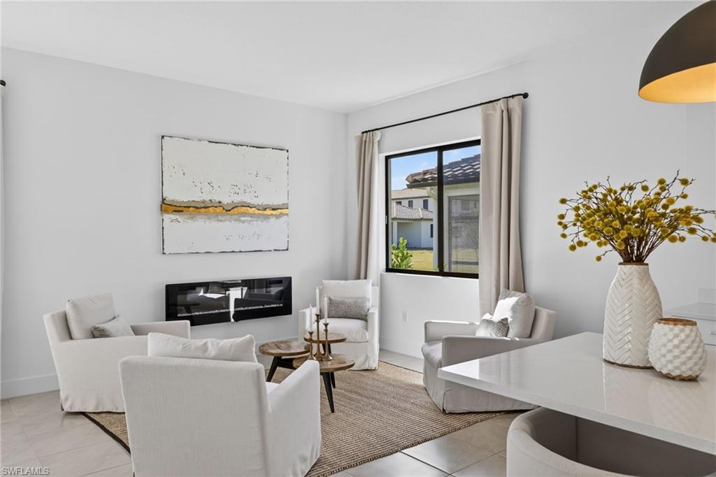 5104 Isidora Lane Ave Maria, FL 34142 - Photo 6 of 28 a living room with furniture a fireplace and a flat screen tv