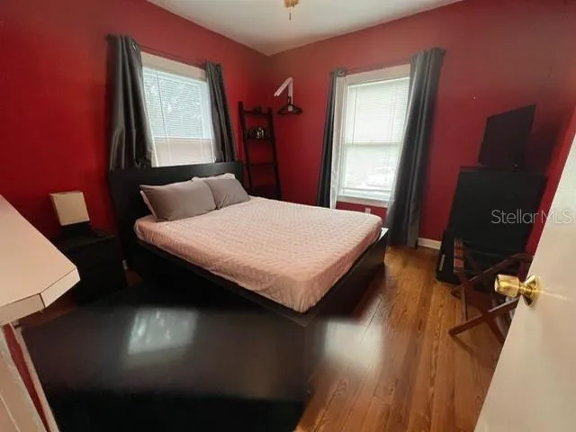 a bedroom with a bed and a dresser next to a window