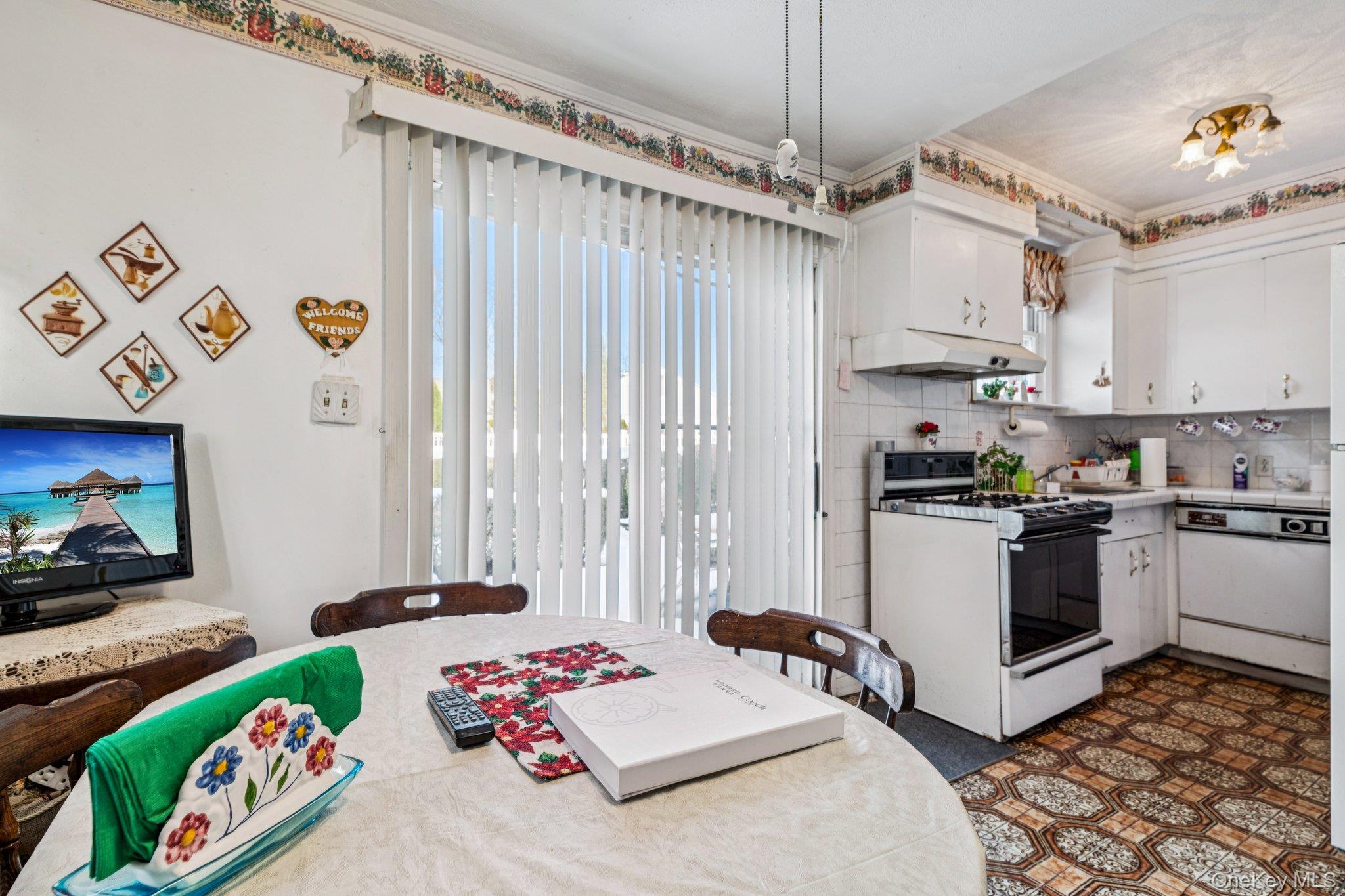 189 Surrey Commons Lynbrook, NY 11563 - Photo 13 of 14 Kitchen featuring light countertops, white appliances, white cabinets, and under cabinet range hood