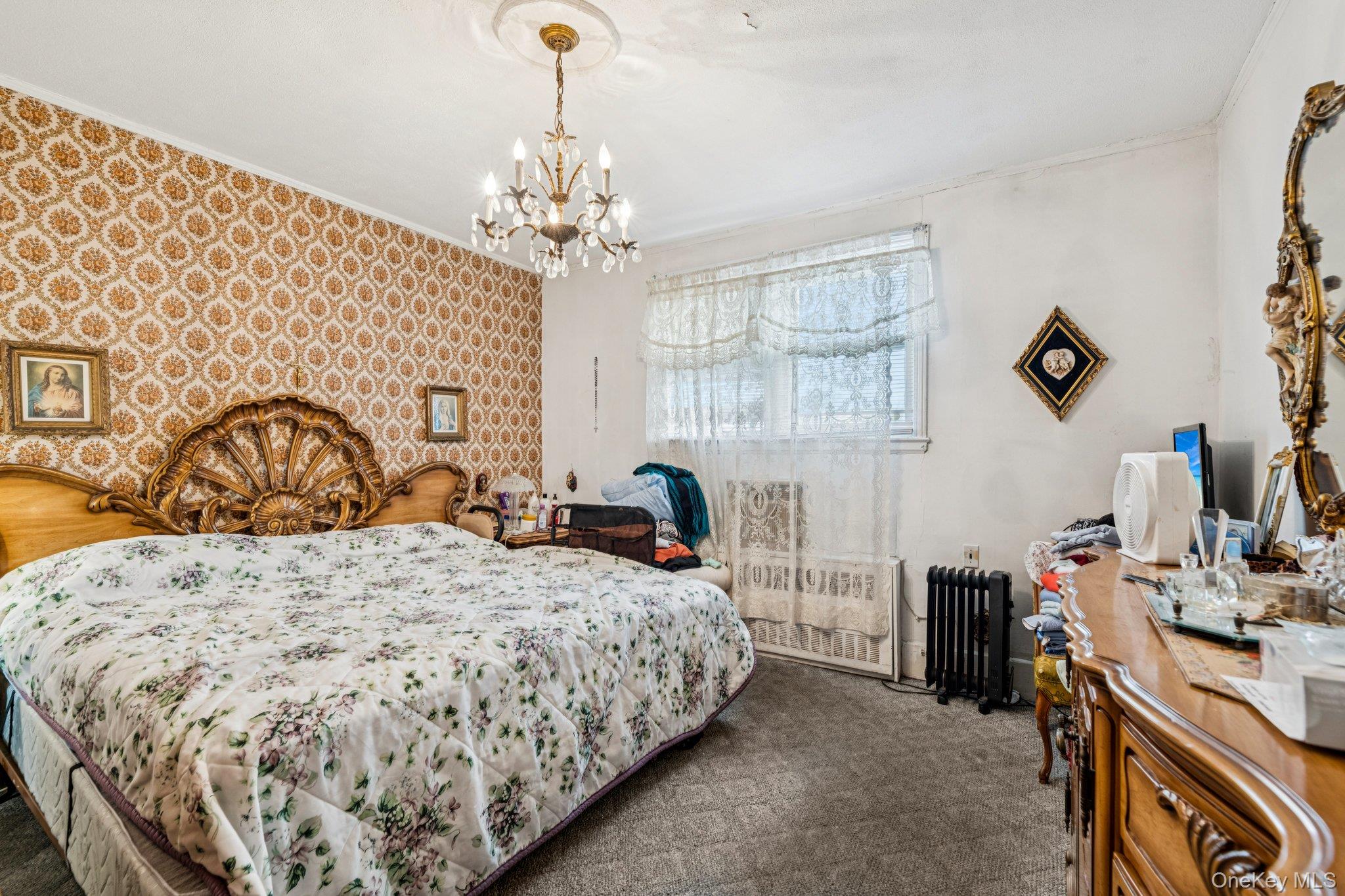 189 Surrey Commons Lynbrook, NY 11563 - Photo 8 of 14 Bedroom featuring wallpapered walls, carpet, an accent wall, radiator, and a chandelier