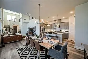 a kitchen with a dining table chairs stainless steel appliances and cabinets