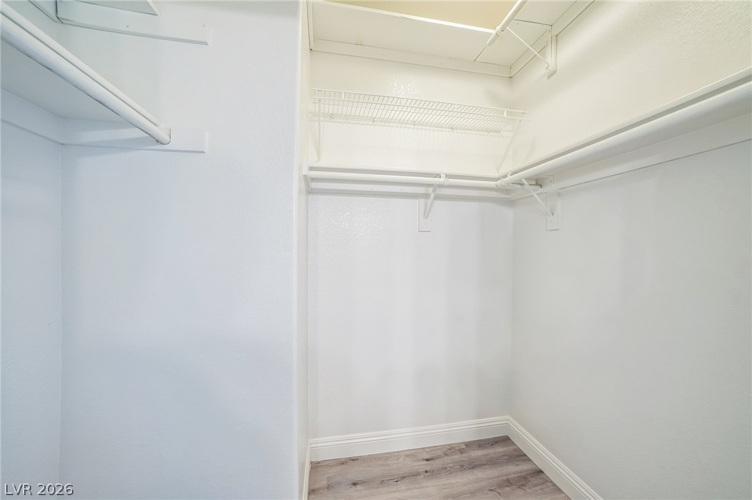 8725 West Flamingo Road, Unit 137 Las Vegas, NV 89147 - Photo 10 of 15 Ample built-in shelving and hanging rods maximize storage within this wood-floored walk-in closet.