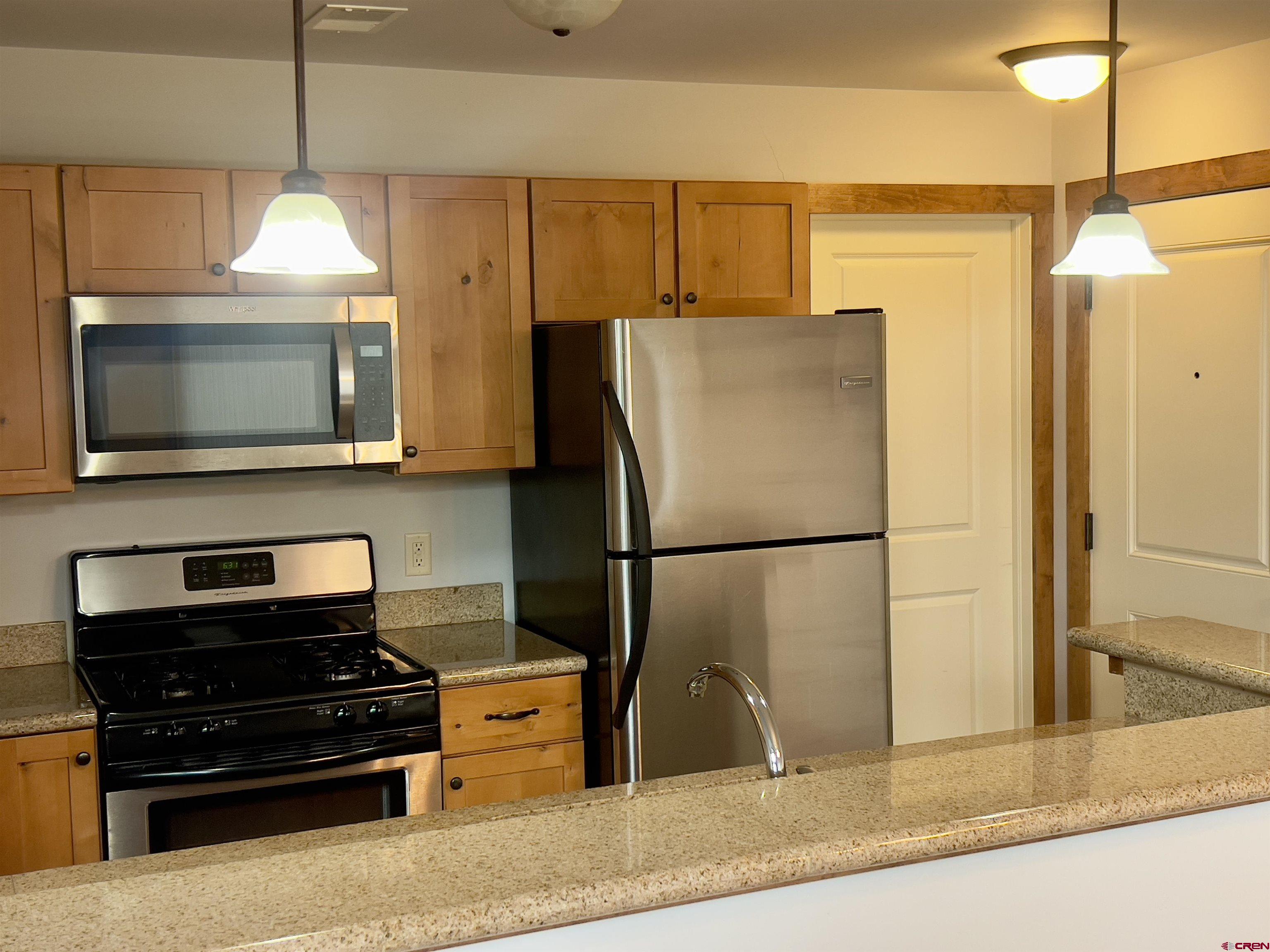 540 Redcliff Circle, Unit E 203 Ridgway, CO 81432 - Photo 9 of 36 a kitchen with stainless steel appliances granite countertop a refrigerator and a microwave