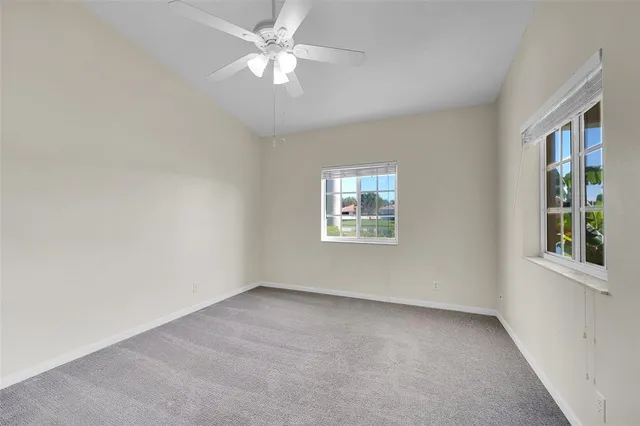 an empty room with a window and a fan