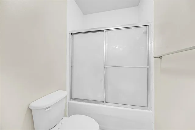 a bathroom with a granite countertop toilet and a shower