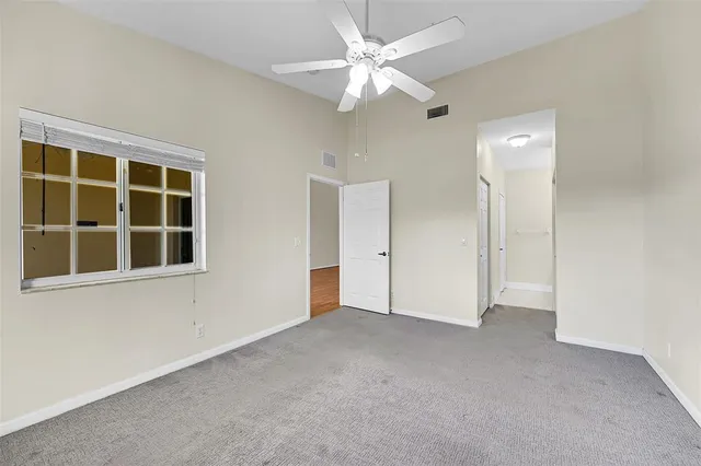 an empty room with a ceiling fan and closet