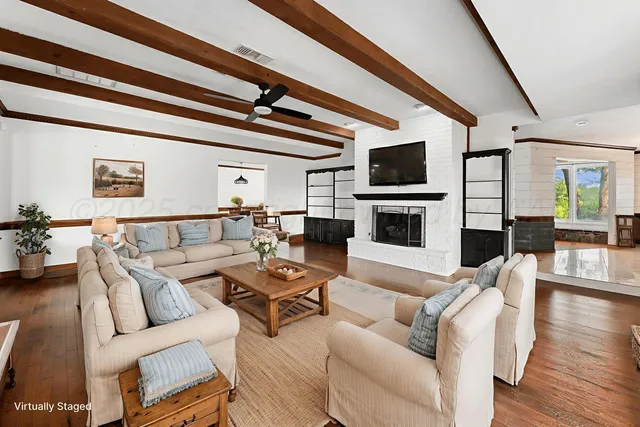 a living room with furniture a flat screen tv and a fireplace