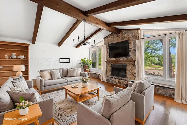 a living room with furniture a flat screen tv and a fireplace